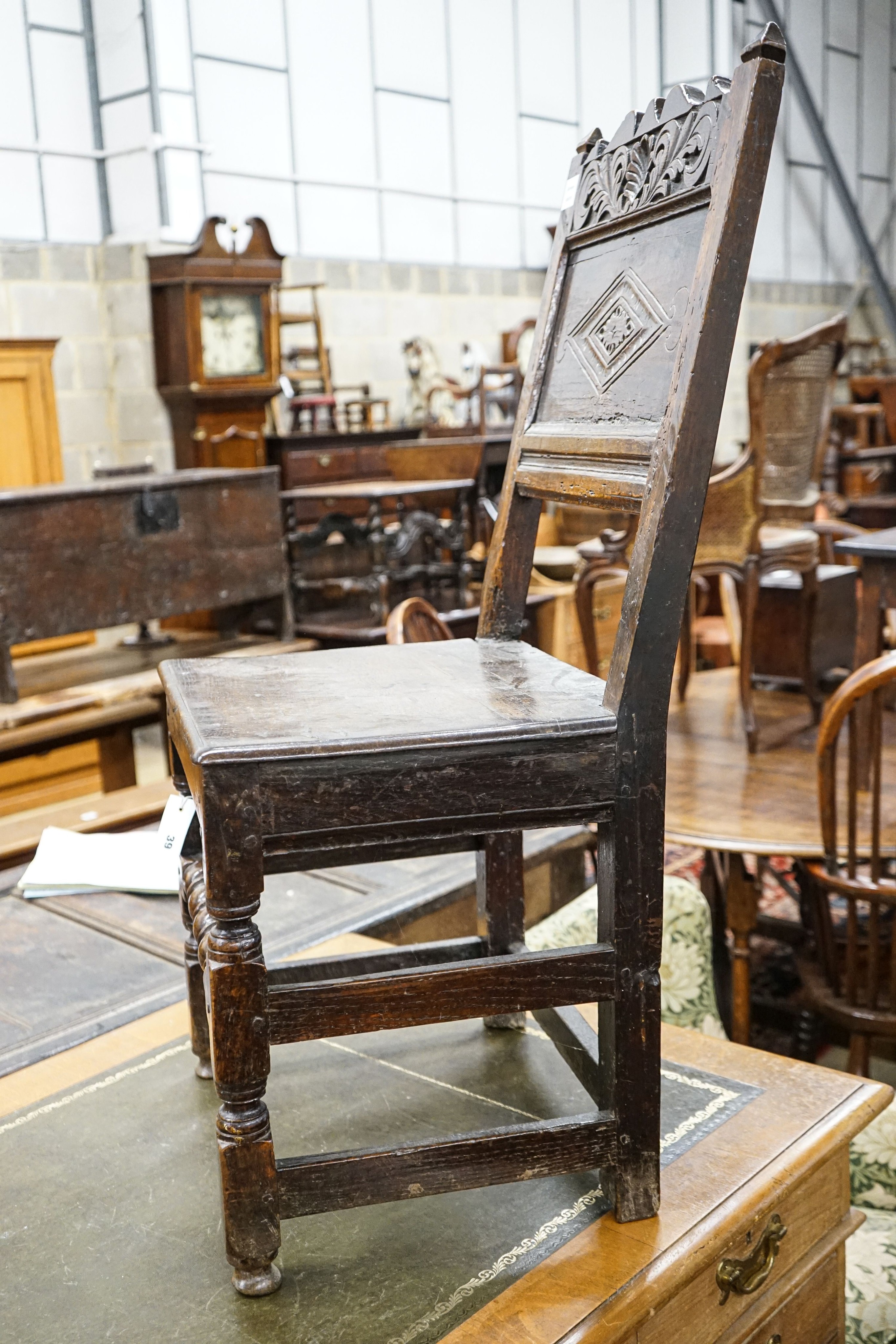 A 17th century oak back stool, with lozenge and foliate carved panelled back and solid seat, on turned and square underframe, width 48cm, depth 40cm, height 97cm, with receipt from Swan Antiques dated 2002